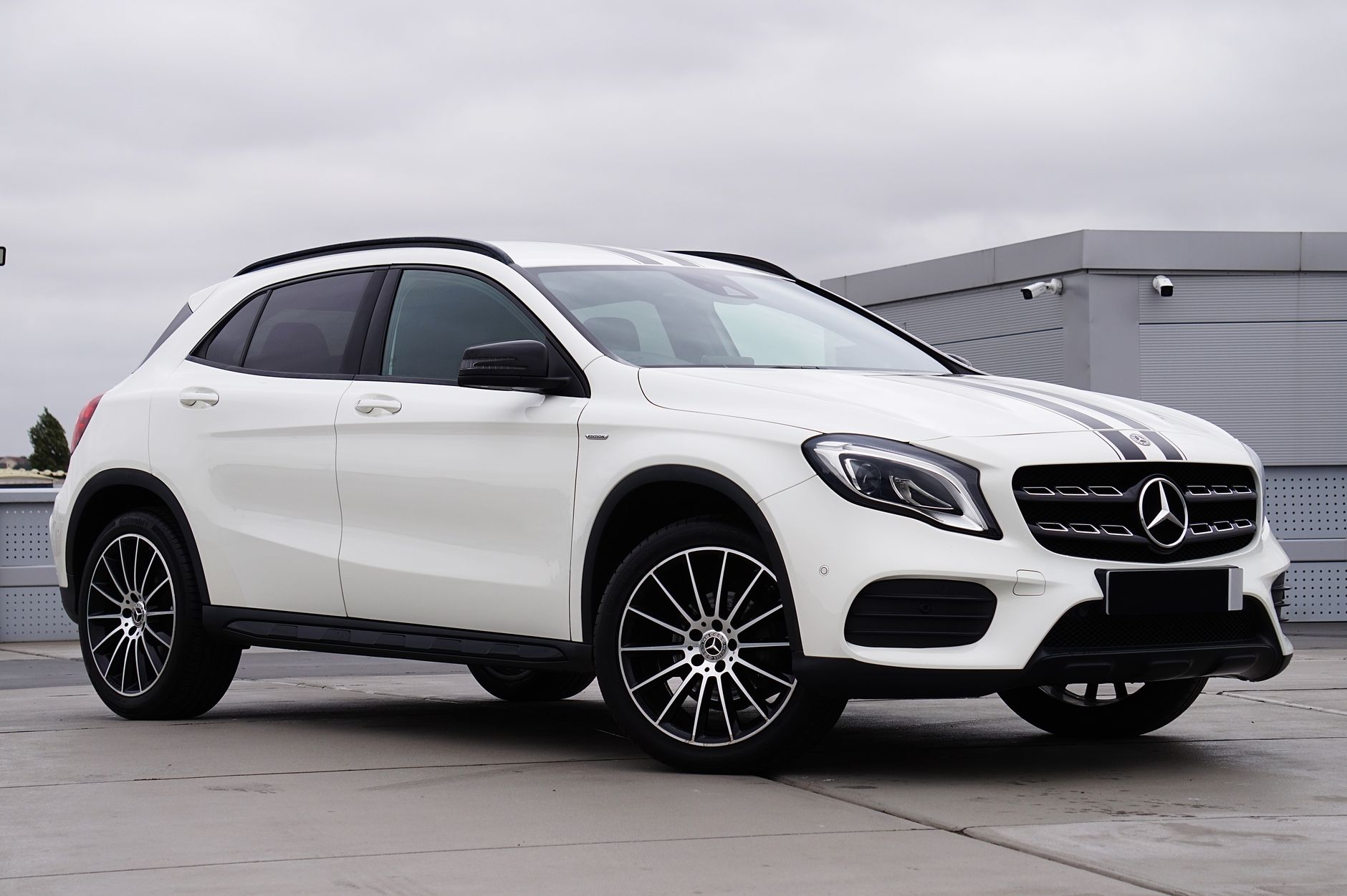 Luxury Mercedes-Benz GLA SUV in white parked outdoors showcasing modern design.