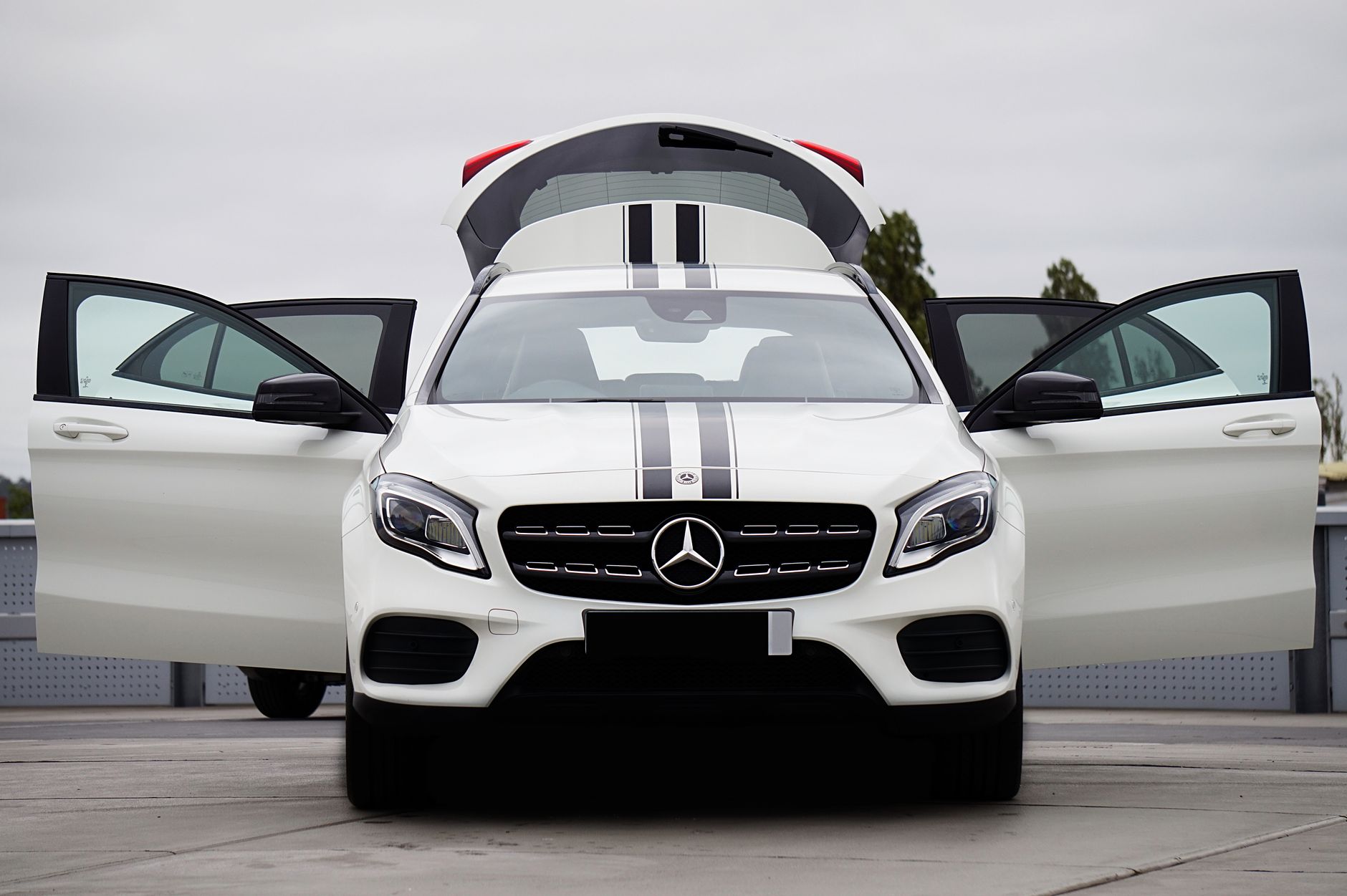 Front view of a luxury white Mercedes-Benz crossover SUV with doors open, showcasing modern design.
