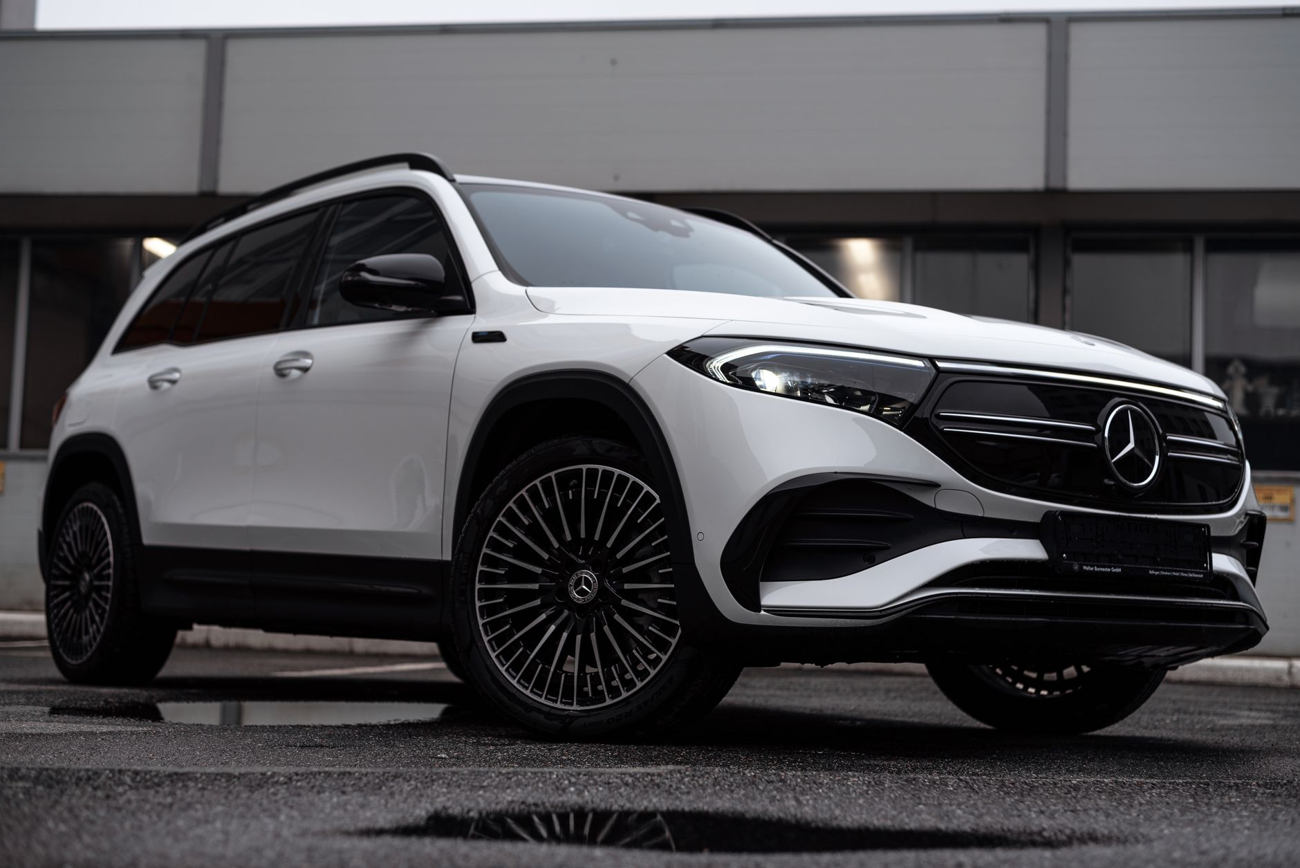 Sleek white Mercedes-Benz EQB SUV parked in a modern urban location.