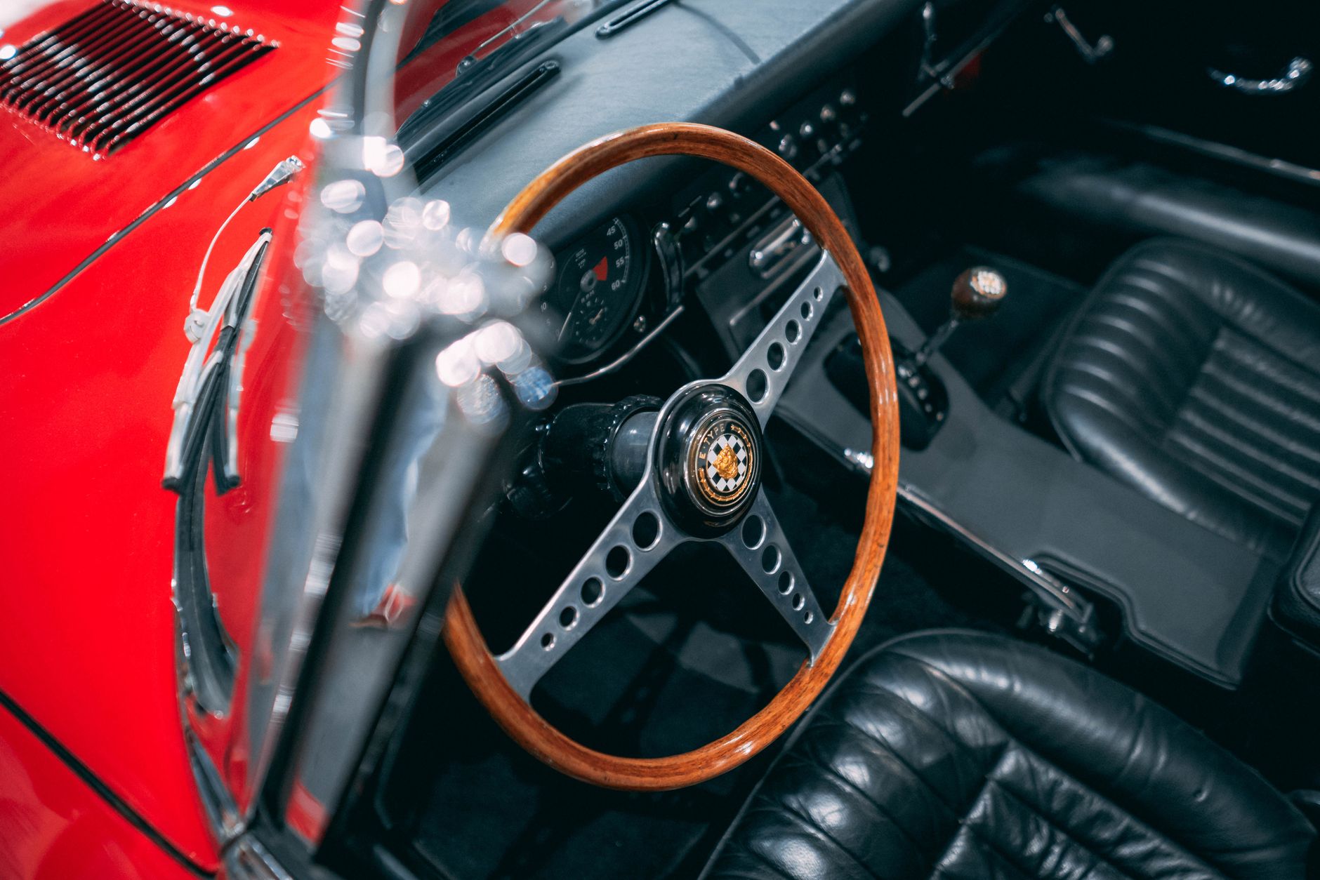 Close-up of a classic Jaguar E-Type interior with wooden steering wheel in Miami.