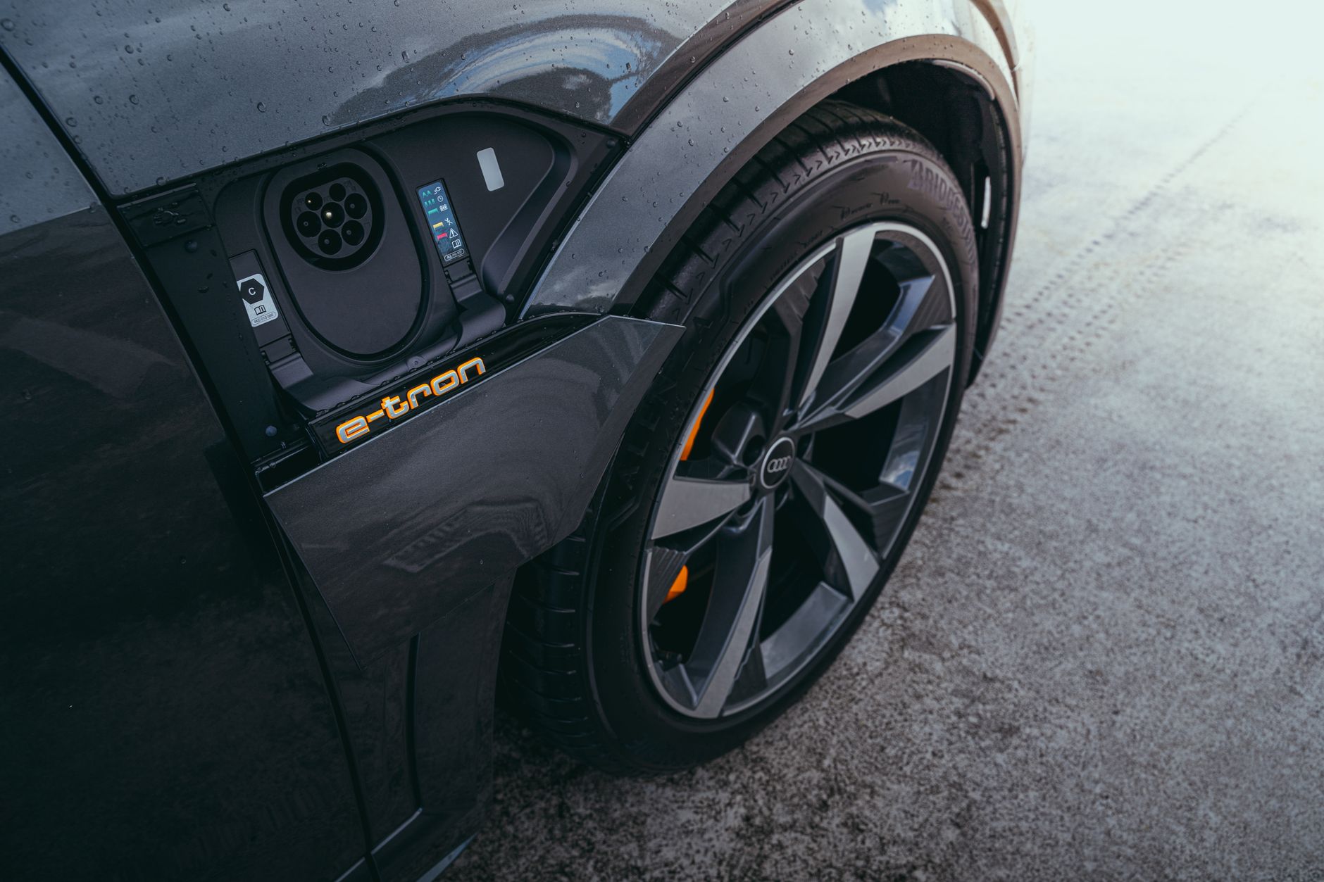 Detailed view of an electric car's charging port and wheel, captured in Curitiba, Brazil.