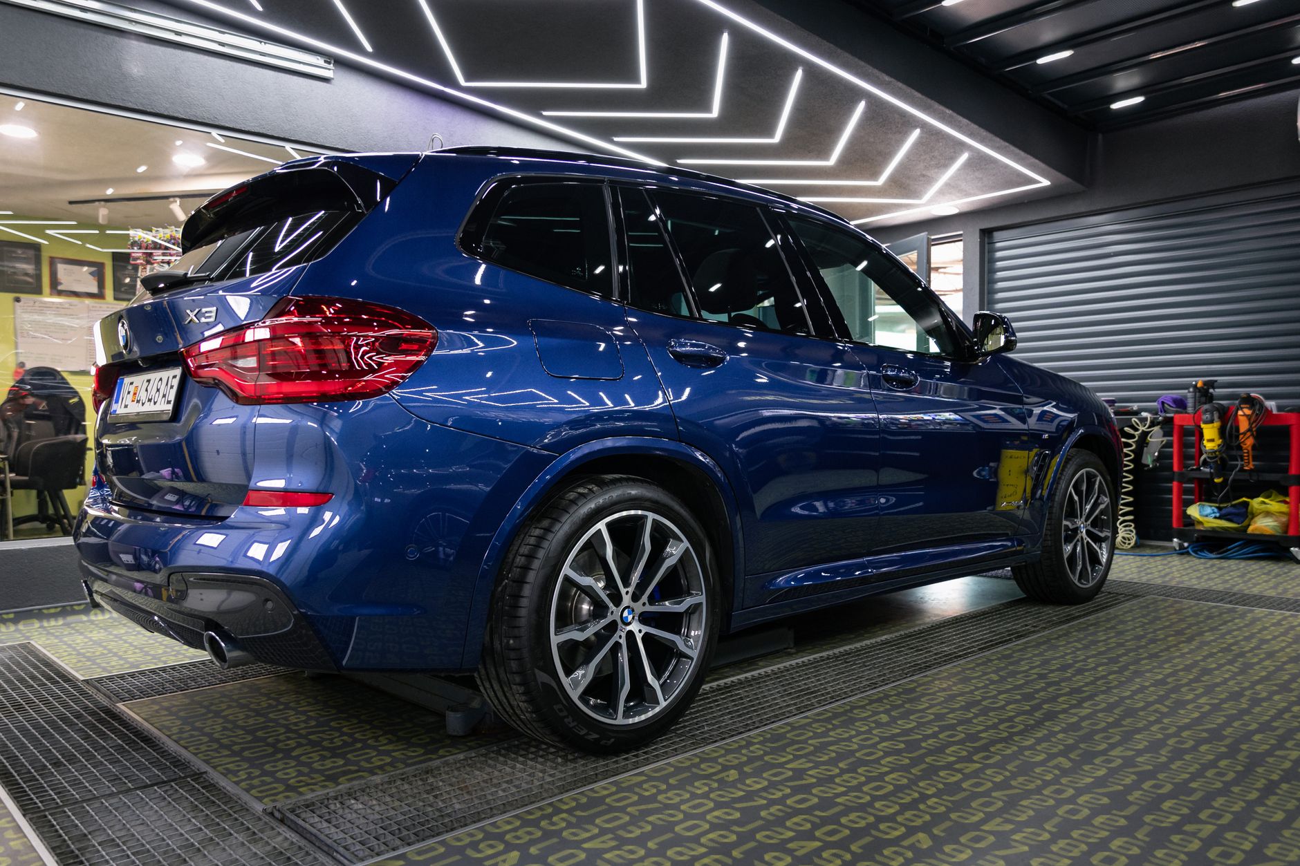 A shiny blue SUV showcased in a sleek modern car dealership, highlighting its design under bright interior lighting.