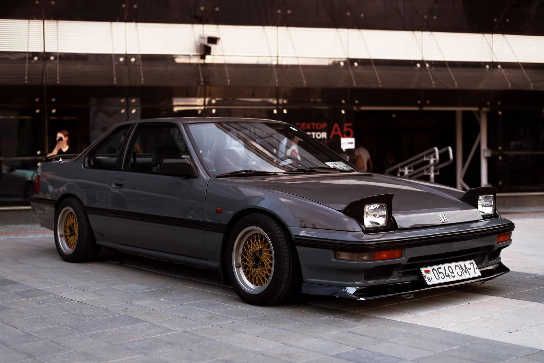 A vintage Honda Prelude parked in an urban area, perfect for auto enthusiasts.