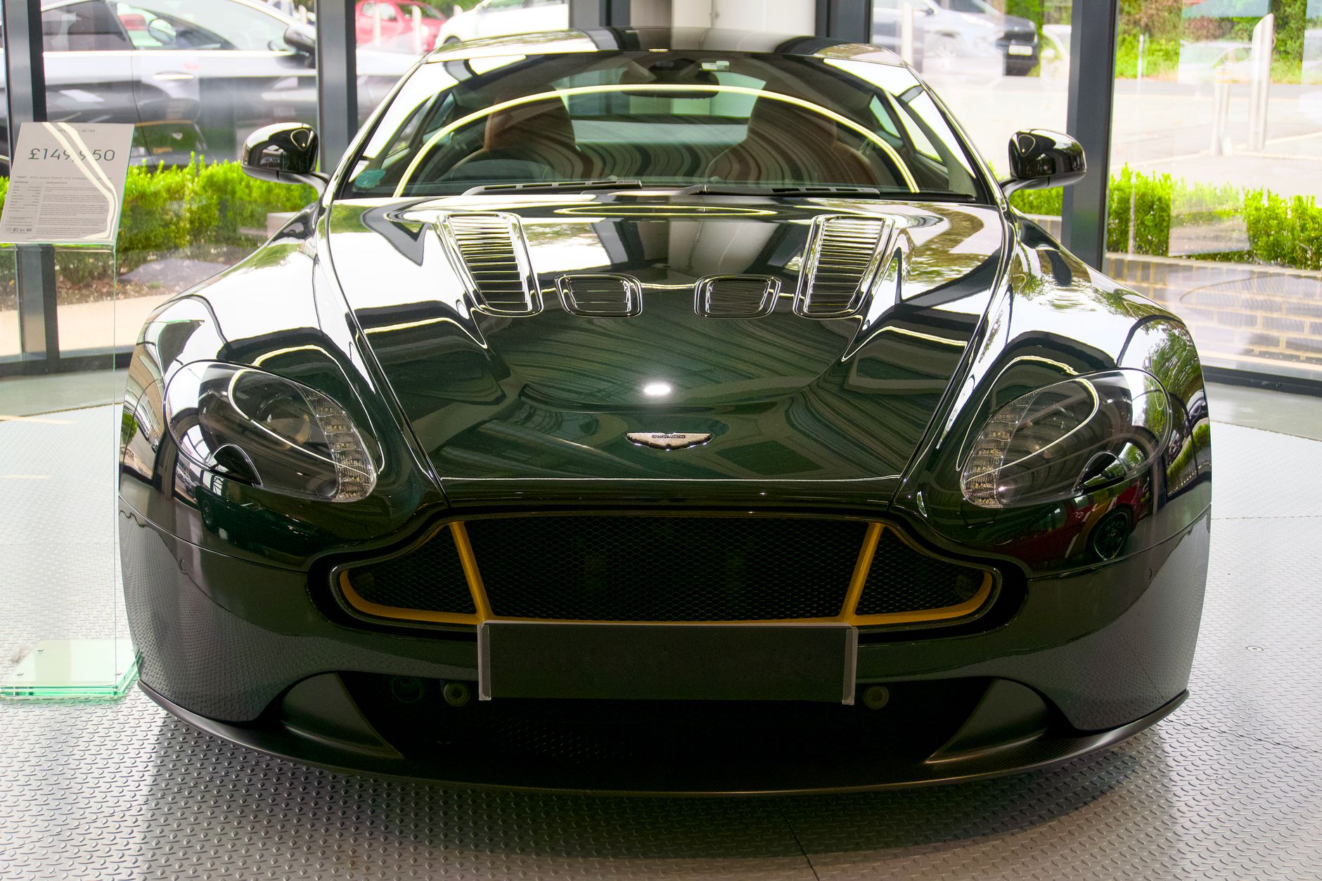 Front view of a luxurious Aston Martin sports car in a showroom setting.