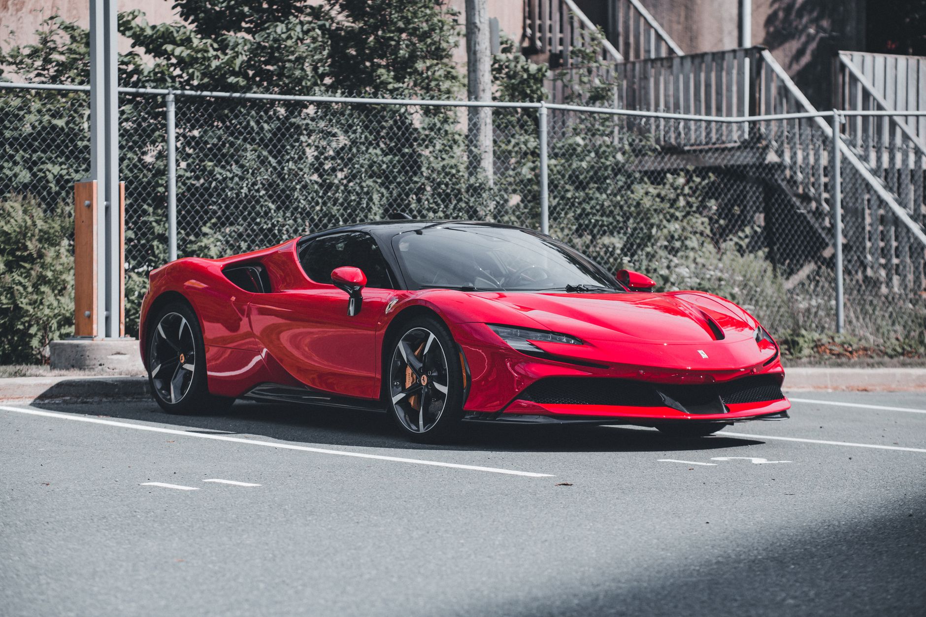 Red Ferrari SF90 Stradale sports car parked outdoors, showcasing sleek design and elegance.