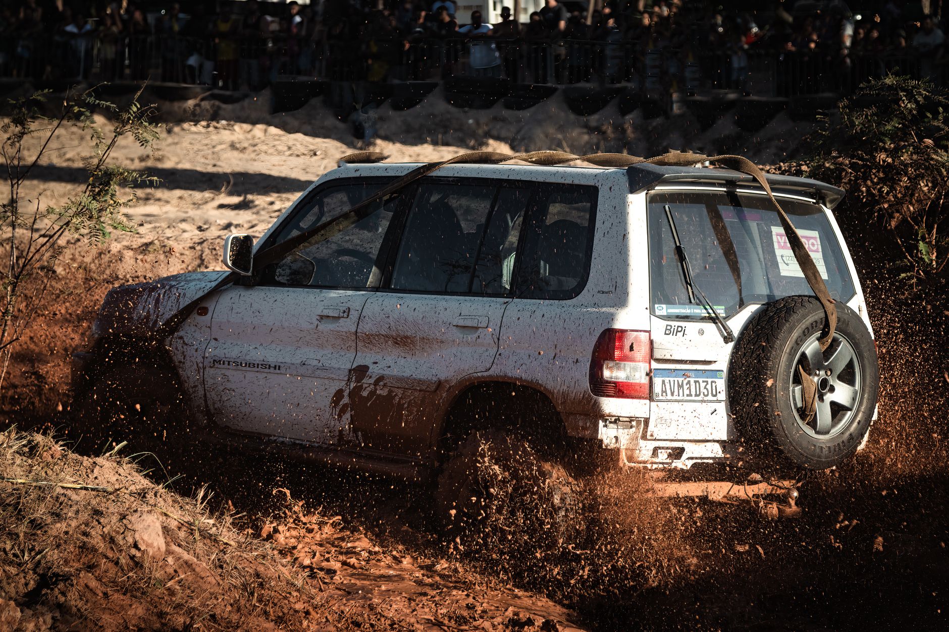 White Mitsubishi Pajero kicks up mud during an exciting offroad adventure.