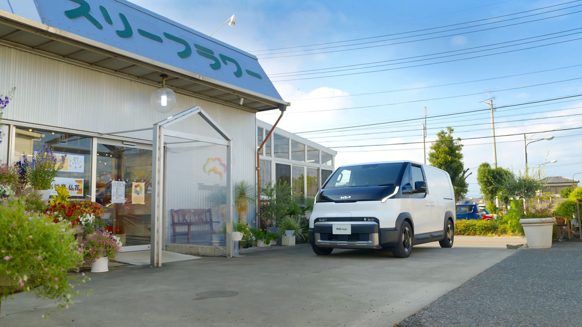 A modern electric van parked outside a flower shop on a clear day, showcasing innovative vehicle design.