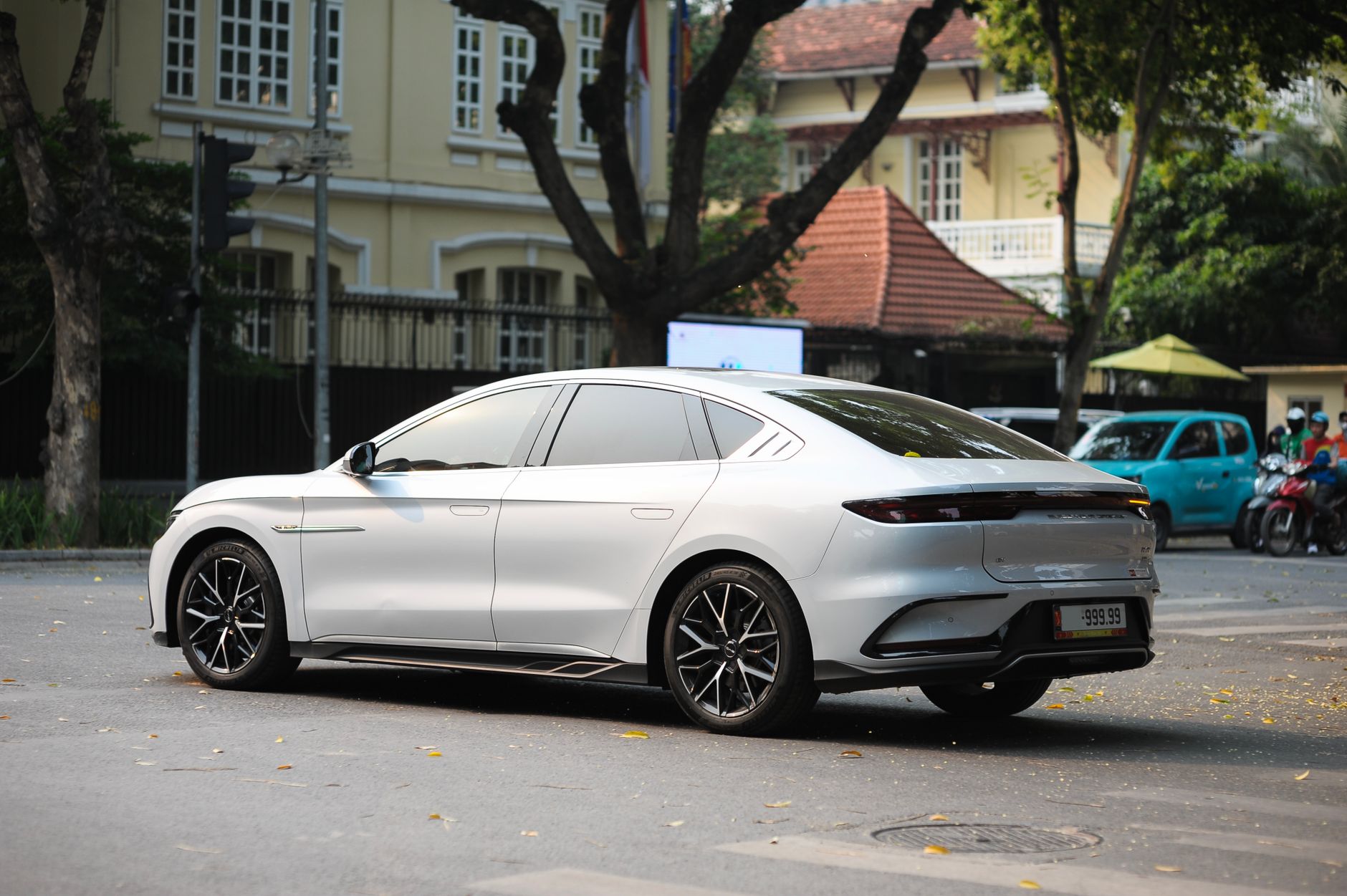 Sleek white electric car parked on a city street with classic buildings in the background.