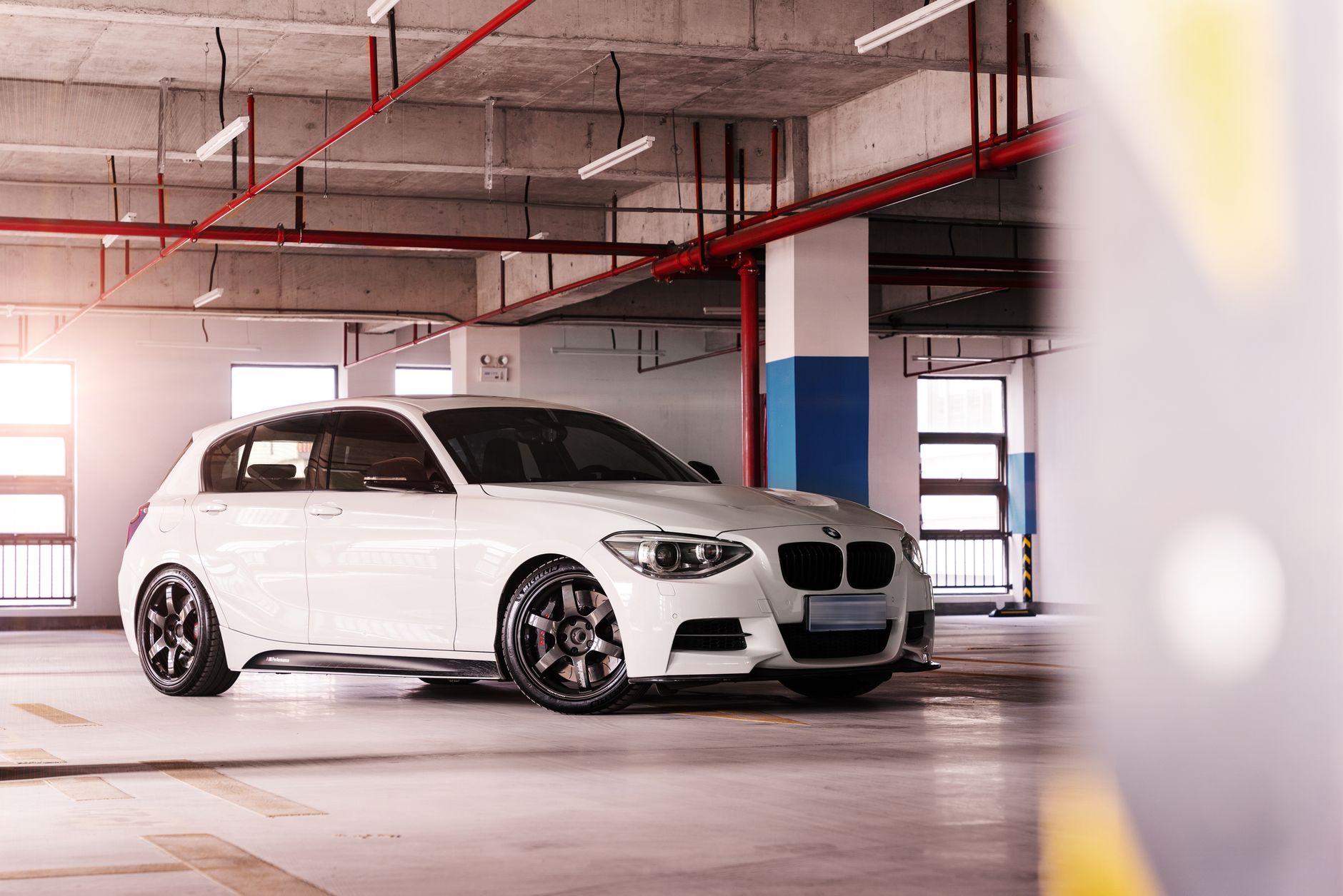 Sleek white BMW hatchback parked indoors, showcasing luxury design and shiny appearance.