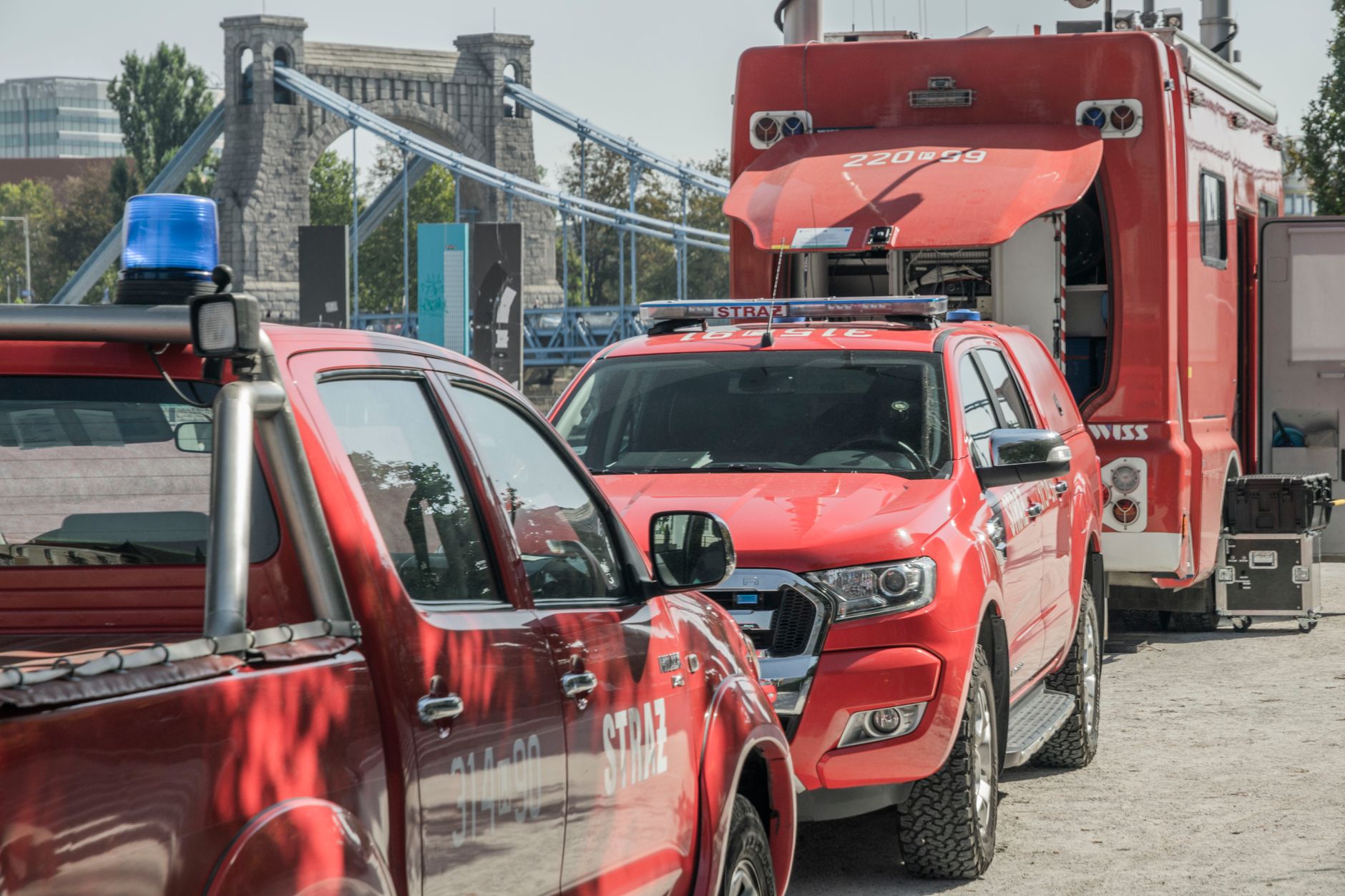 Fire service vehicles parked near a bridge in Wrocław, showcasing an emergency response scene.