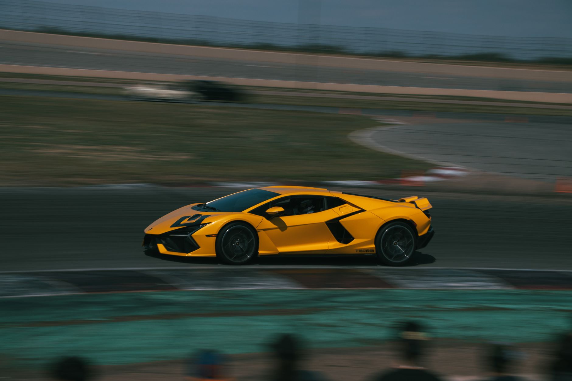A sleek yellow Lamborghini speeding on a race track in Colorado, showcasing automotive excellence.