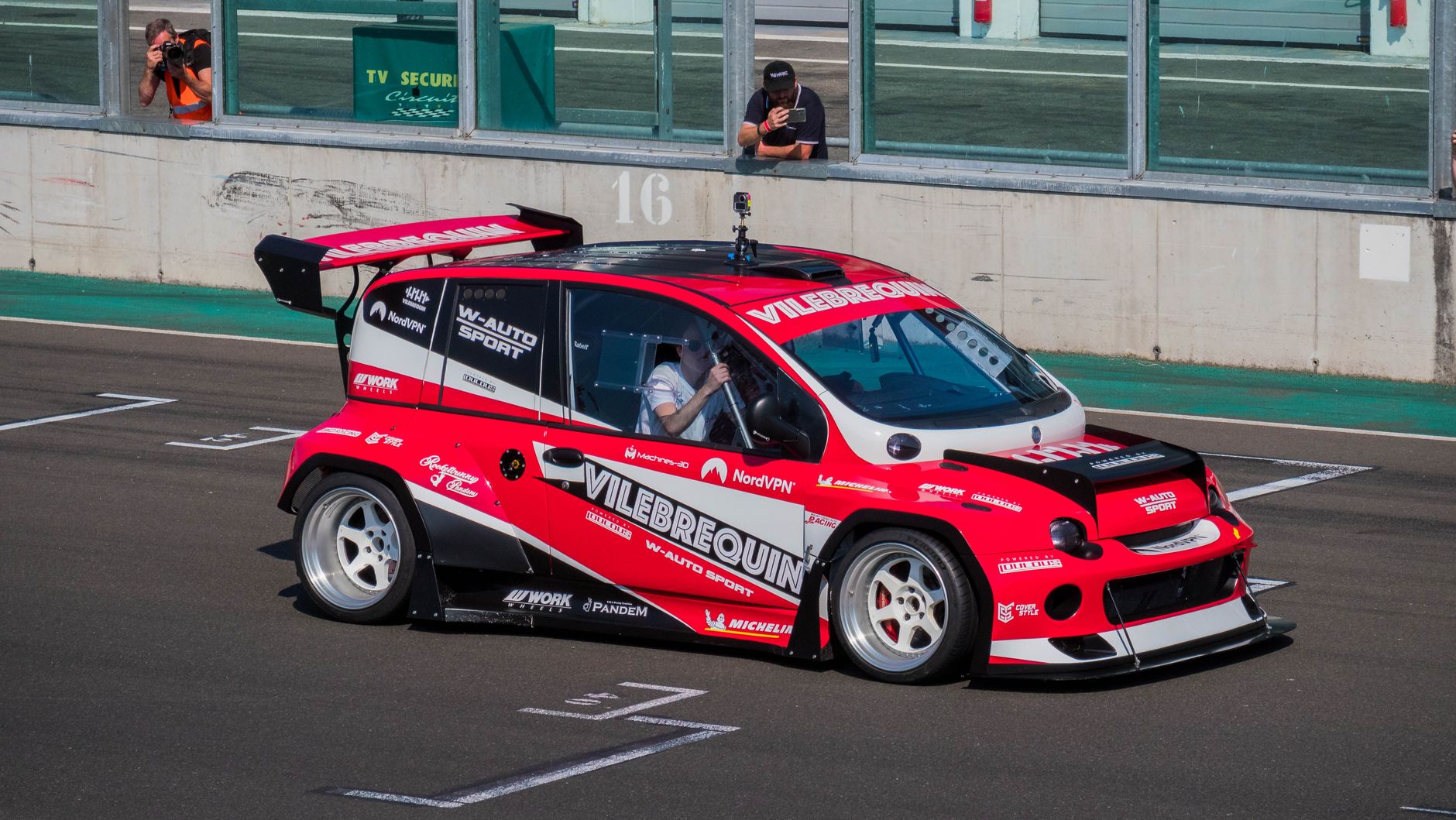 Fiat Multipla in red livery racing on a track during a motorsport event.