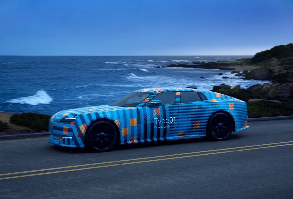 Zamaskowany prototyp elektrycznego Jaguara podczas jazdy testowej nad oceanem.