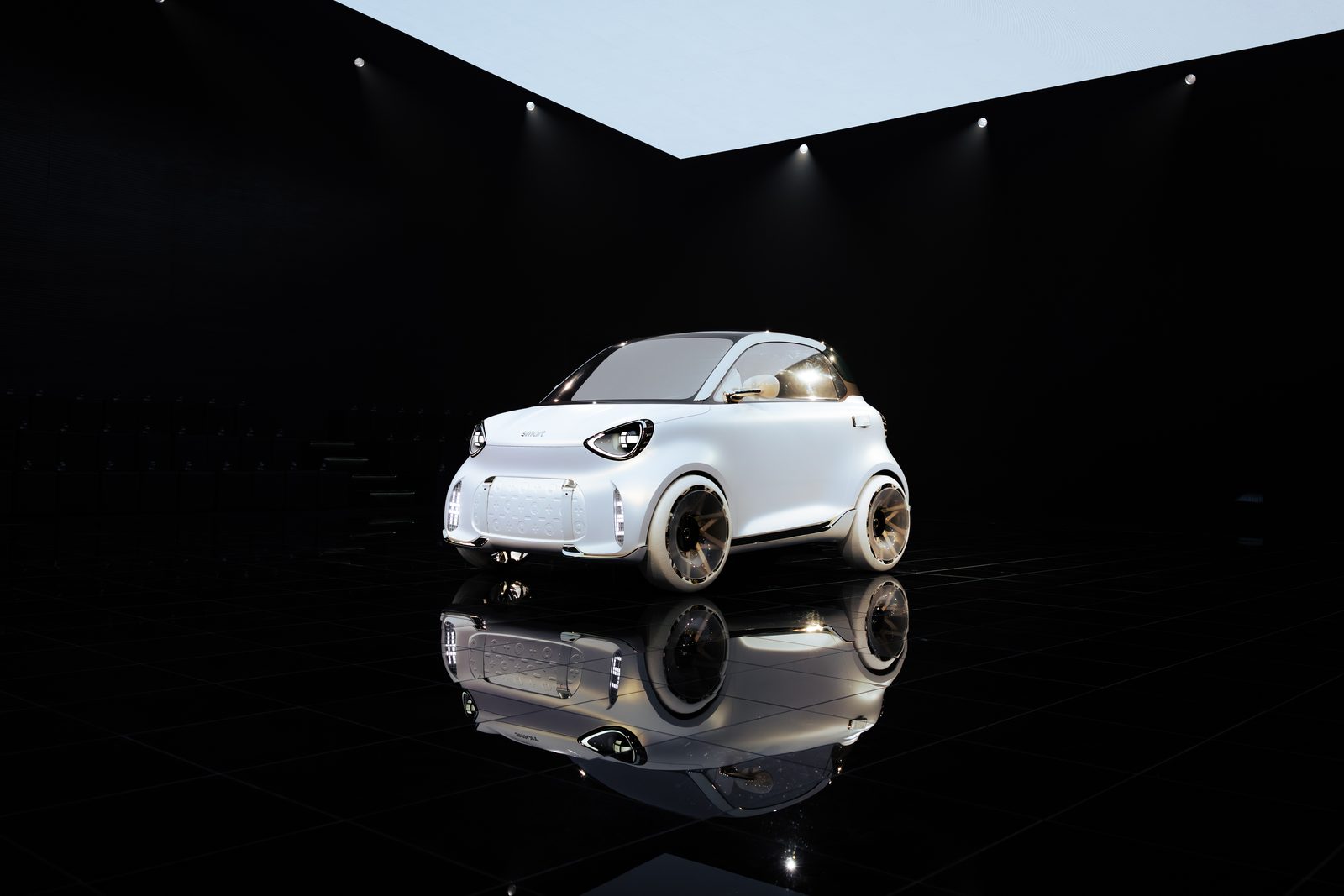 A white electric car is plugged in for charging, close-up view of the charging port.