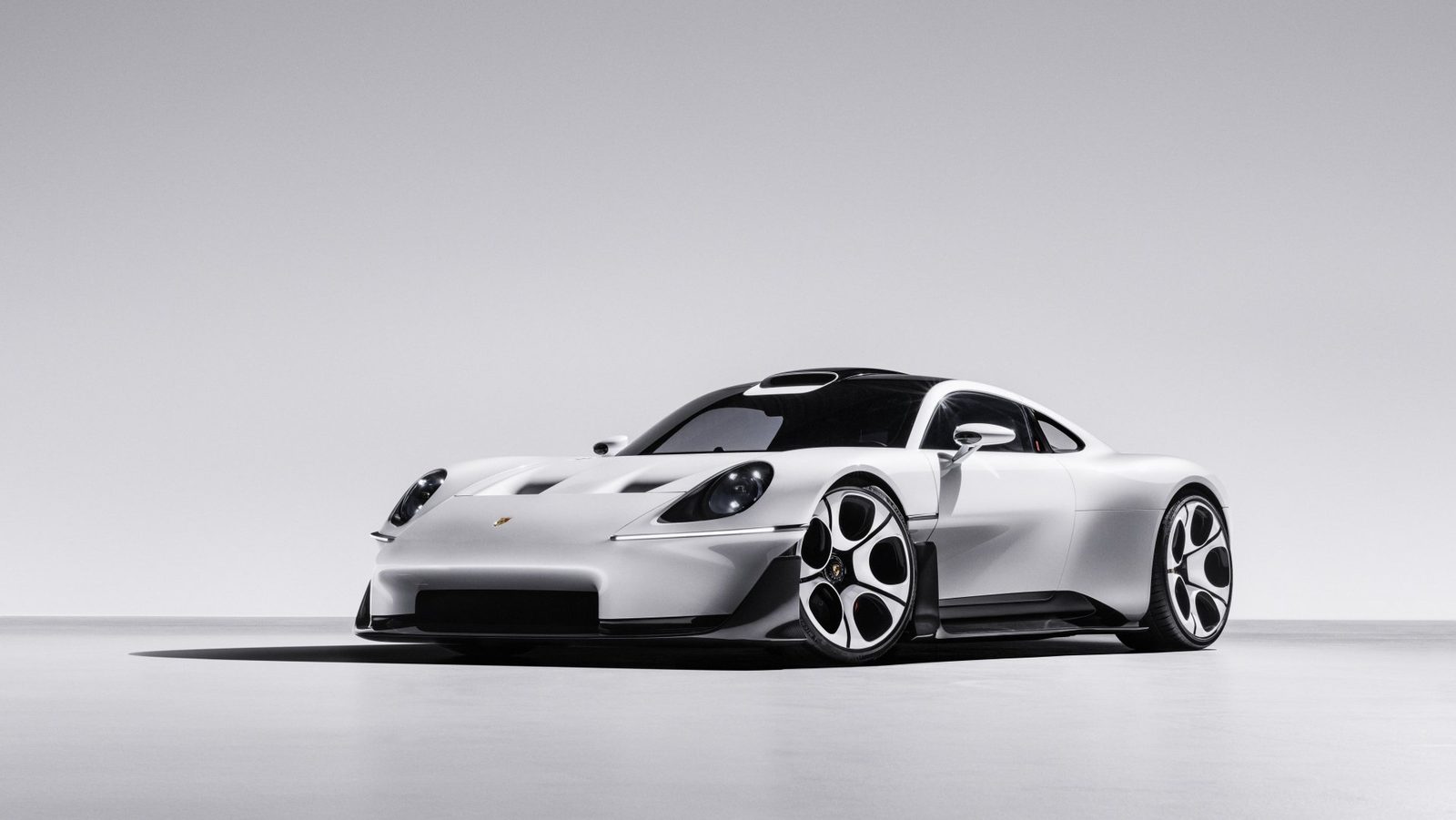 Białe sportowe Porsche o aerodynamicznej sylwetce zaprezentowane w minimalistycznym studiu.