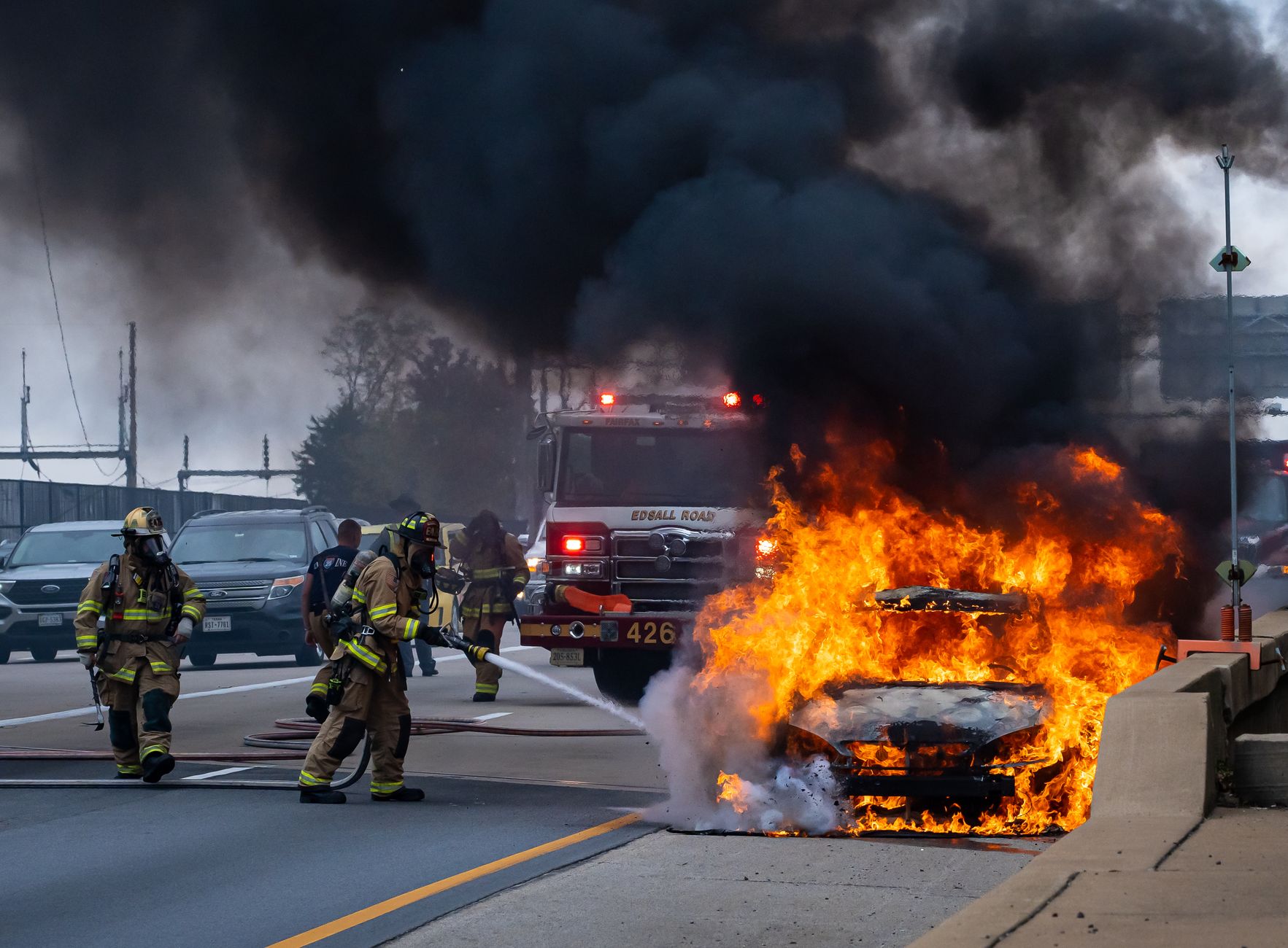 Dramatic scene of firefighters tackling a burning car on a busy highway in Springfield, VA.
