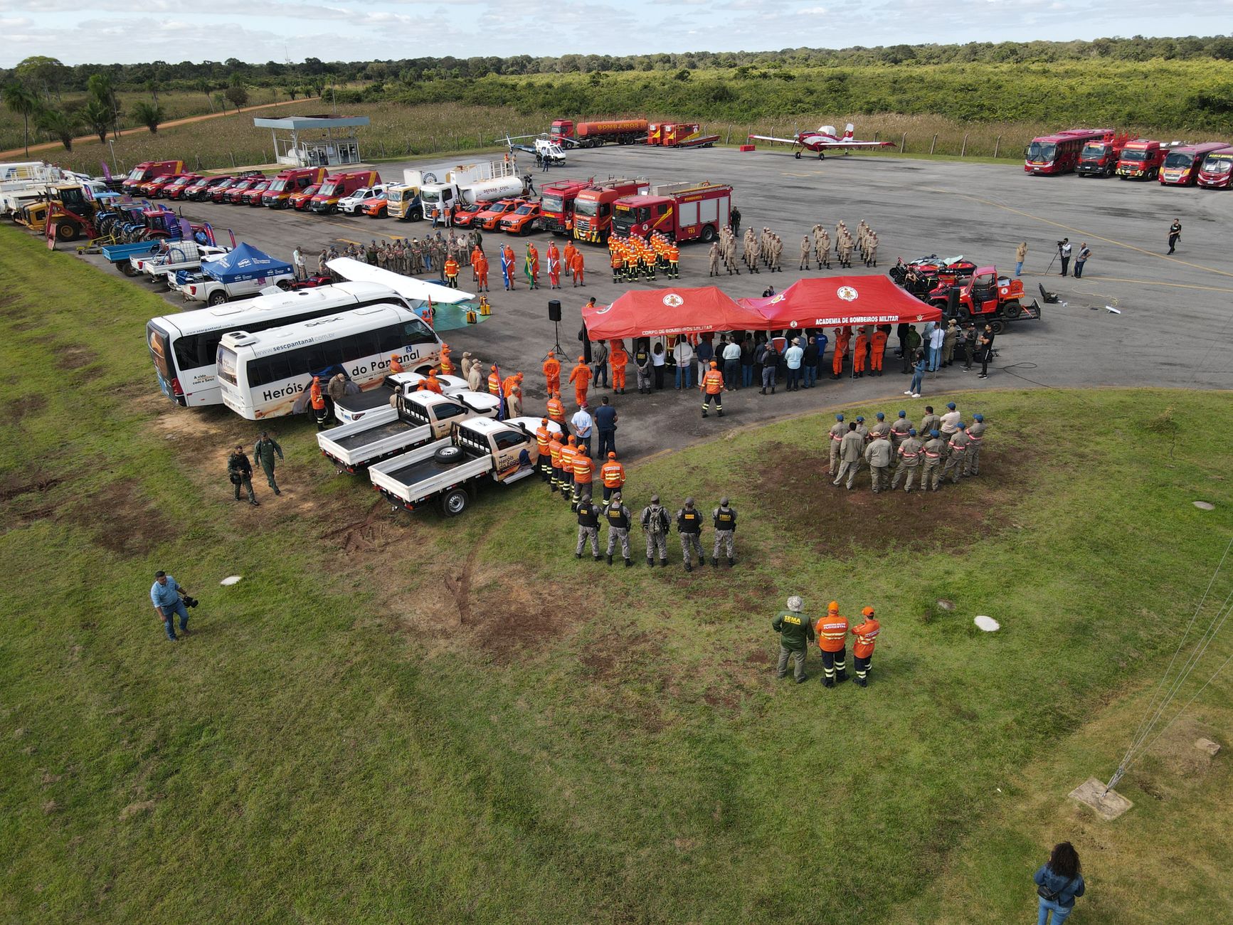 Aerial shot of firefighters coordinating at an outdoor meeting area with vehicles and equipment.