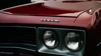Close-up of a Dodge Challenger RT's front grille and headlamps, showcasing the classic muscle car's iconic design.