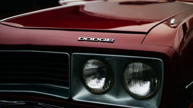 Close-up of a Dodge Challenger RT's front grille and headlamps, showcasing the classic muscle car's iconic design.