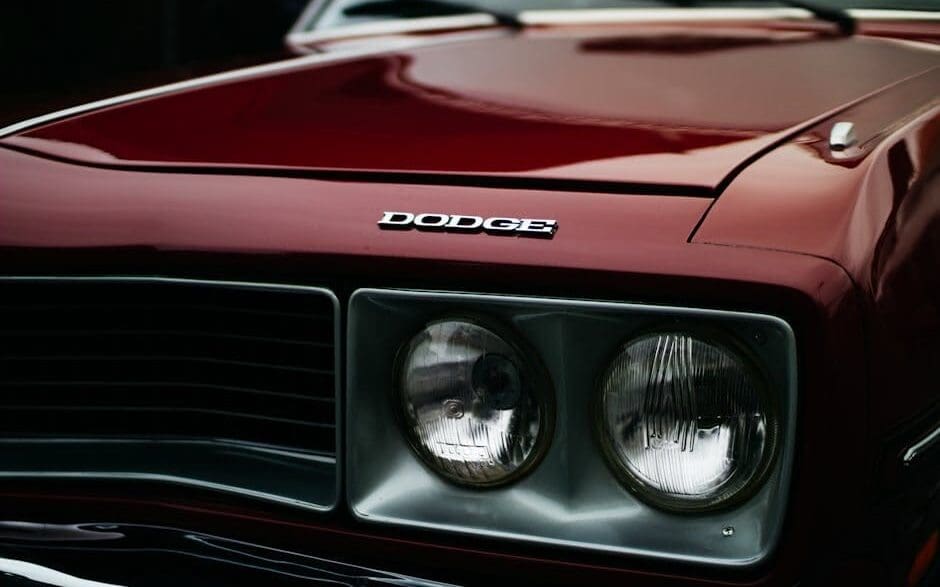 Close-up of a Dodge Challenger RT's front grille and headlamps, showcasing the classic muscle car's iconic design.