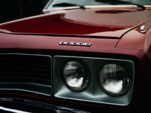 Close-up of a Dodge Challenger RT's front grille and headlamps, showcasing the classic muscle car's iconic design.